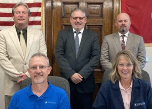 PHOTO: Moore (seated left) new Noble County Health Commissioner, Shari Rayner (seated right), Director of Nursing at the Health Department . . Also pictured are (standing): Noble Co. Commissioners Gary Saling, Allen Fraley, and Tyler Moore.